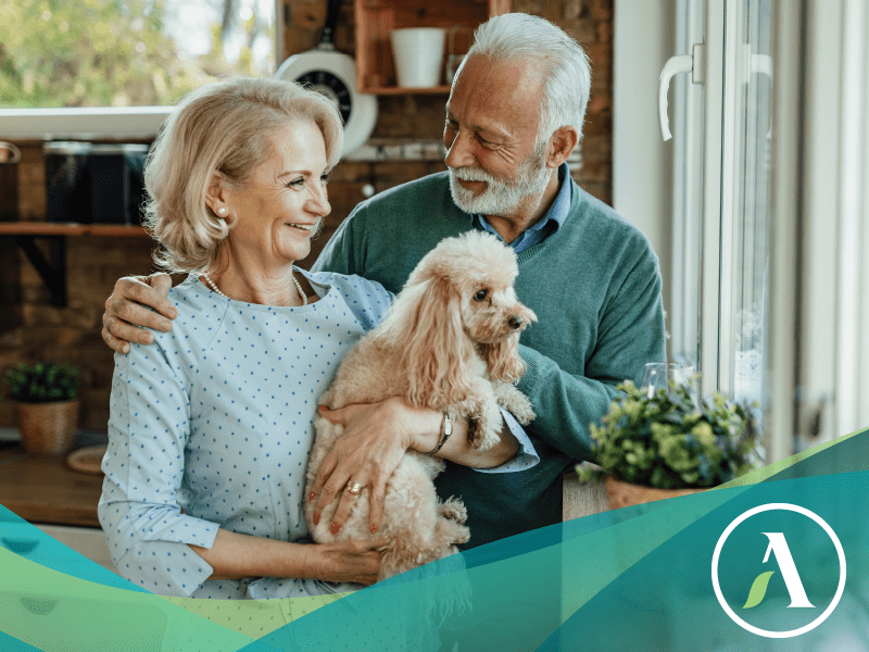 Senior couple smiling and holding dog