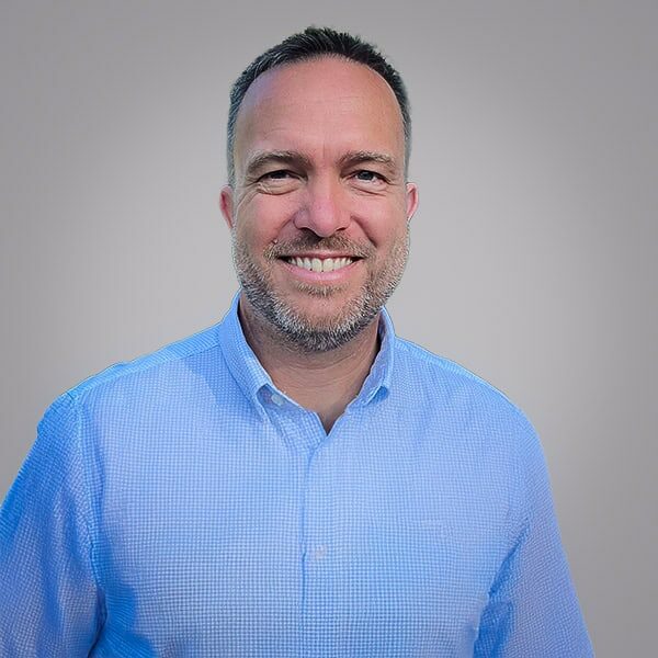 Brian Koning smiles at the camera in a blue shirt.